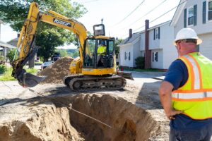 Waterworks crew in the field using backhoe and NCT service line puller kit to pull a new water supply line 